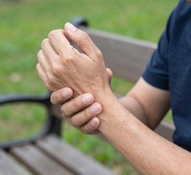 A person gently holding their painful knee, showing discomfort in a realistic, softly colored horizontal image.