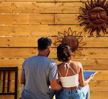 Couple sitting outdoors on a wooden deck using a tablet and enjoying some quality time.