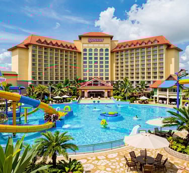 A group of enthusiastic travel entrepreneurs collaborating over laptops and travel brochures in a bright, modern office.
