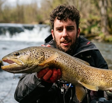 Pescador con gran trucha en un río de León