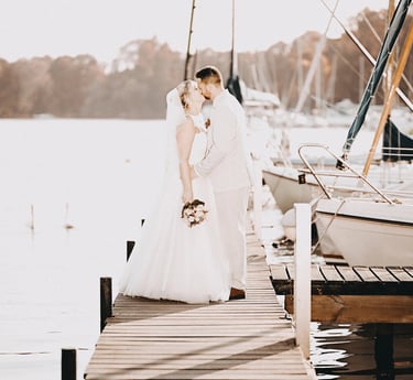 Brautpaar küsst sich auf einem Steg am Möhnesee bei Sonnenlicht – romantischer Moment eingefangen vom Hochzeitsfotografen am 
