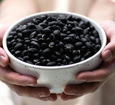 Imagen de manos sosteniendo un plato de frijoles negros