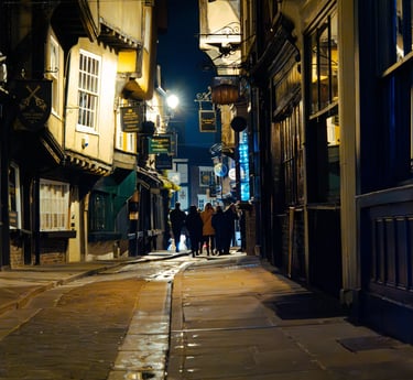 a person walking down a street at night at York shambles