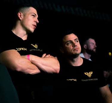 two men sitting on a stage with their arms crossed