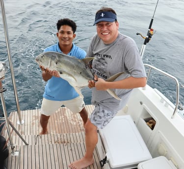 Happy guest with caught fish during sport fishing experience in Gulf of Papagayo, Costa Rica