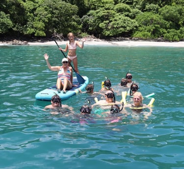 Family snorkeling in crystal-clear waters of Guanacaste during private catamaran tour Costa Rica