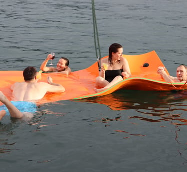 Guests relaxing on floating mat with cocktails during luxury catamaran experience in Papagayo