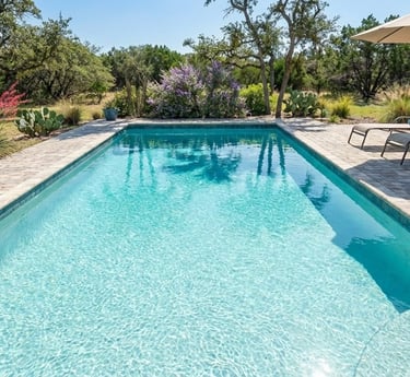 A sparkling clean swimming pool on a bright sunny day in a Central Texas backyard.