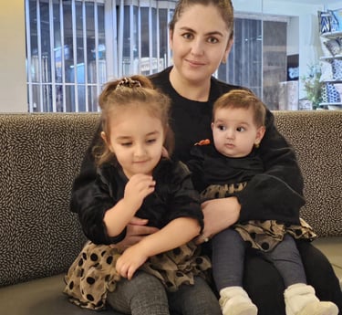a woman sitting on a couch with two children