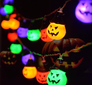 Colorful Halloween string lights shaped like glowing jack-o’-lanterns in orange, green, purple, and 