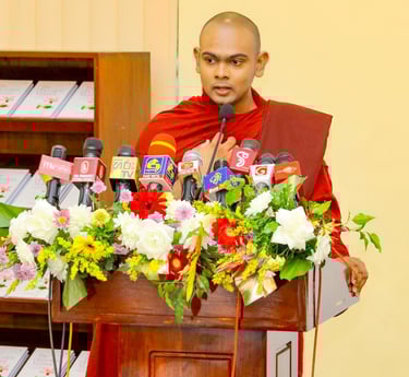 a monk in a red robe speaking into a microphone