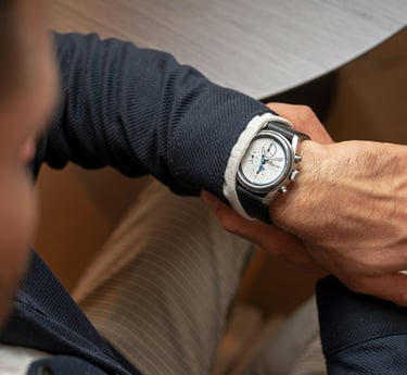 a man in a suit and tie is holding a watch