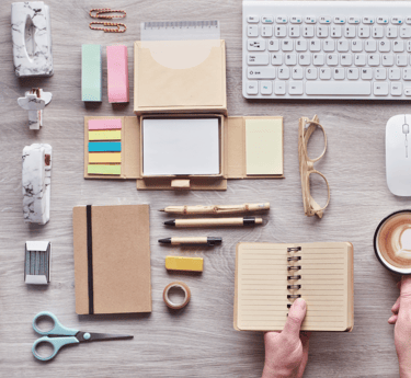 a person holding a cup of coffee and a notebook