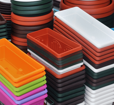 a bunch of different colored plastic containers flower pots