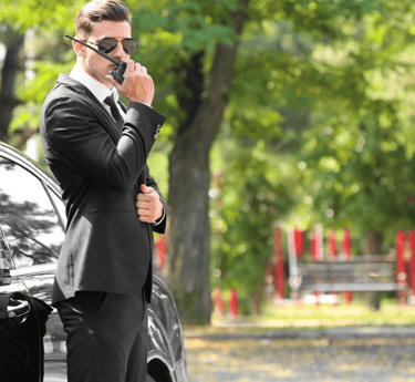 Force Prévention Sécurité – Agent de sécurité en costume noir, équipé d'une oreillette et d'un talkie-walkie, assurant la pro