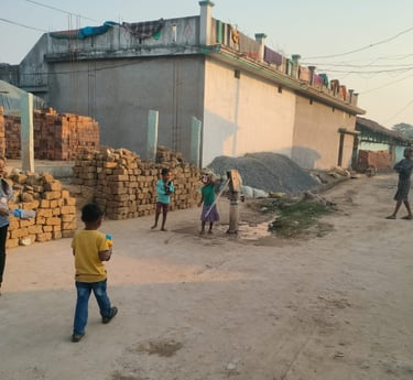 A girl stand near handpump with a boy