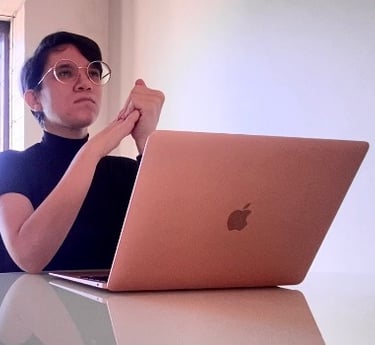 a woman sitting at a table with a laptop computer