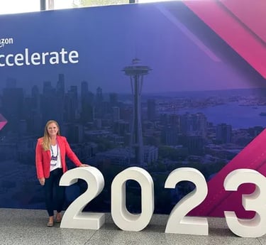 Colleen Quattlebaum standing in front of a sign that says, "Amazon accelerate 2023"