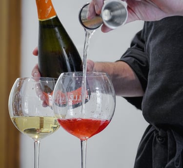 a person pouring wine into wine glasses