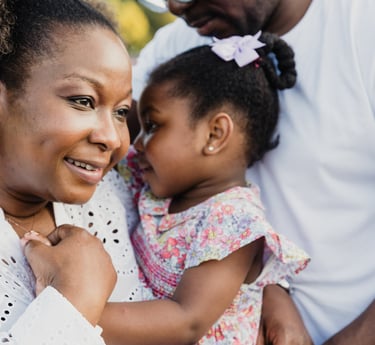 a woman holding a toddler and smiling 