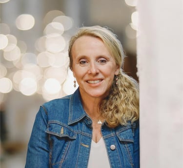 Photo of Chris Bisner who is smiling with her long blonde hair is pulled into a low pony.