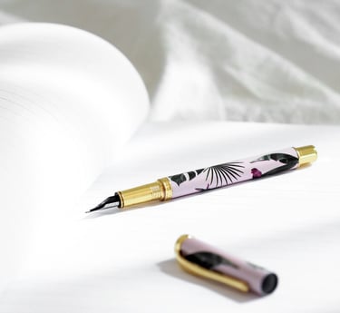 Elegant floral fountain pen with gold trim resting on a white lined notebook page.