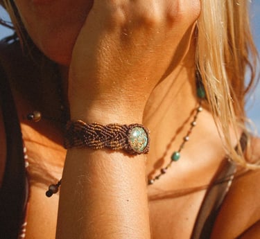 Pulsera de macramé café con piedra turquesa en la muñeca