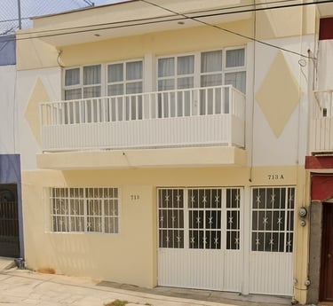 a building with a white and yellow building with a red door