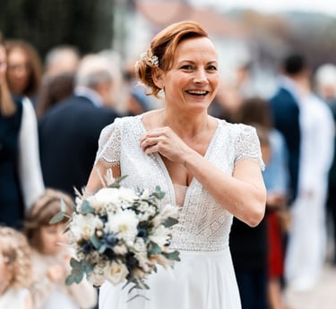 Une femme en robe de mariée un bouquet de fleurs à la main