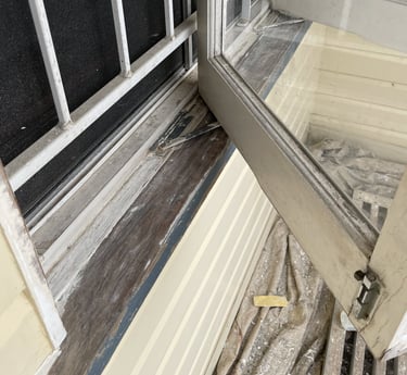 Window sill and frame before repainting showing worn timber and weather damage