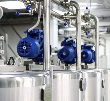 Tanques industriales de fermentación de acero inoxidable con motores eléctricos azules en una cervec