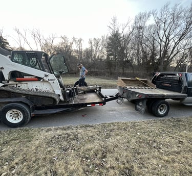 truck with skid steer on trailer