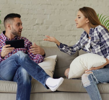 Couple in conflict on sofa, representing the need for marriage counselling