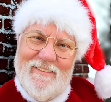 Santa Meik in a santa claus costume with a santa clause hat