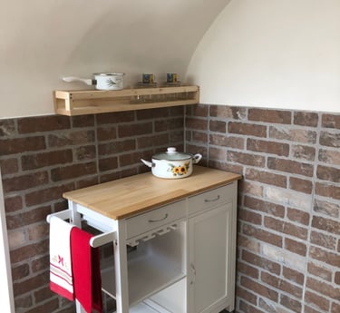 a kitchen with a small table and shelves