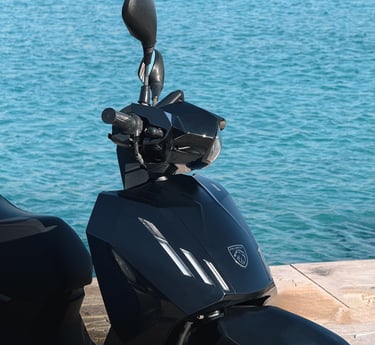 a motorcycle parked on a wooden deck near the water