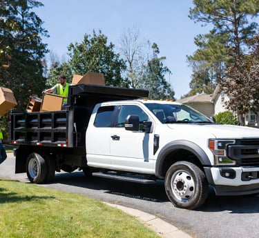 JK Cleanup team loading household junk into 2024 Ford F-550 dump truck during professional junk remo