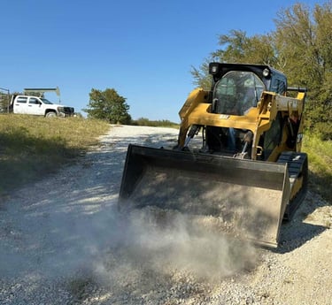 a skid steer working on a gravel road