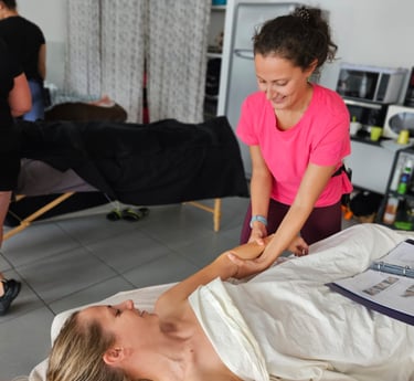Massage de l'avant-bras avec masseuse et personne allongée sur le dos sous un drap