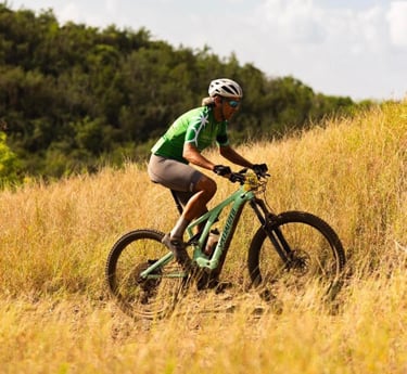 a man riding a bike through a field