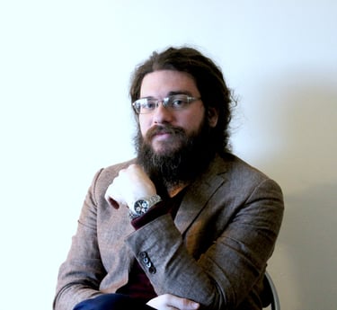 a man with a beard and glasses on a chair