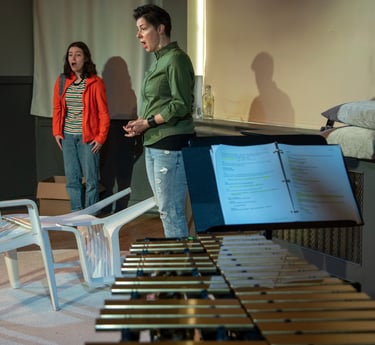 A preteen and her mom stand with their mouths hanging open, in the foreground we see a vibraphone.
