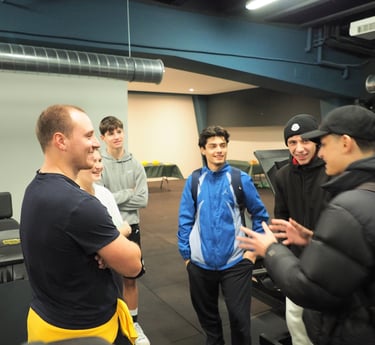 Gruppo di giovani che chiacchierano con un istruttore nella palestra Move 2 Grow a Milano, in un ambiente accogliente e motiv