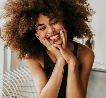 une femme aux cheveux afro bouclés et vêtue d'une robe noire