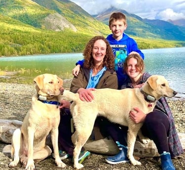 Dr. Brooks and her two kids and dogs at lake with mountains