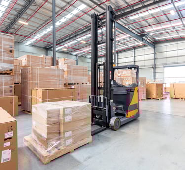a forklift truck in a warehouse with boxes of boxes