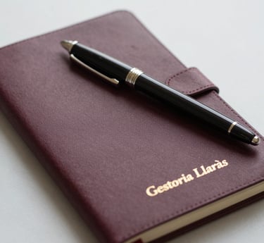 A stack of office ring binders and documents on a desk with an accountant working in the background.