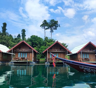  Schwimmende Holzbungalows auf dem Khao Sok See in Thailand mit einem traditionellen Langboot 