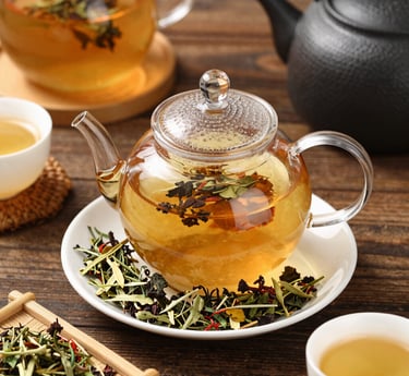A cozy scene of a steaming cup of herbal tea surrounded by fresh herbs and dried leaves on a rustic wooden table.