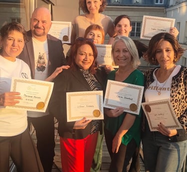 Groupe d’élèves souriants tenant leurs certificats à la fin d’une formation de massage, photographié